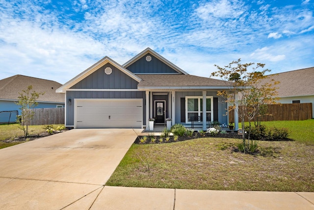 view of front of property with covered porch, a garage, and a front lawn