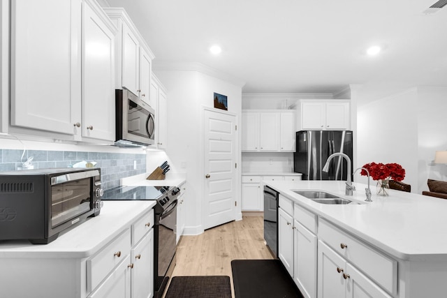 kitchen with sink, black appliances, a center island with sink, light hardwood / wood-style flooring, and white cabinets