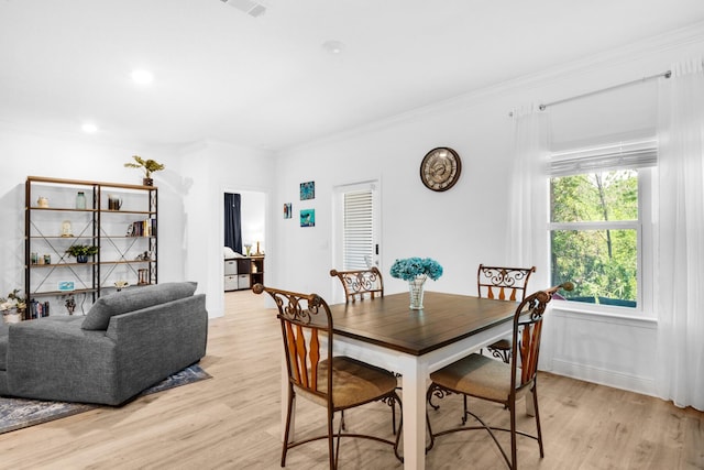 dining room featuring ornamental molding and light wood-type flooring