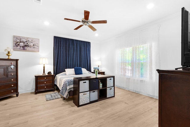 bedroom with ceiling fan, light hardwood / wood-style floors, and ornamental molding