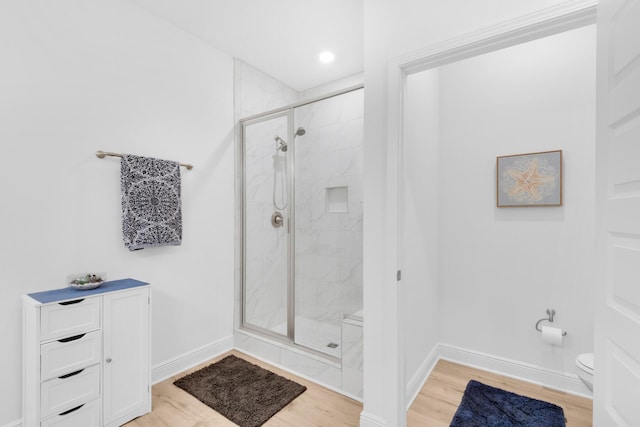 bathroom featuring hardwood / wood-style floors, toilet, and walk in shower