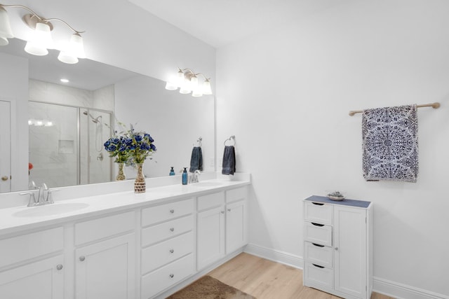 bathroom with hardwood / wood-style flooring, vanity, and an enclosed shower