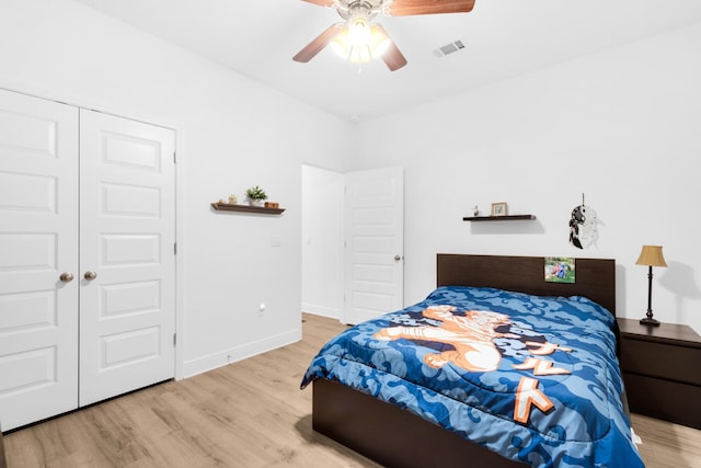 bedroom featuring ceiling fan, light hardwood / wood-style flooring, and a closet