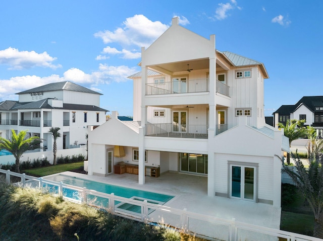 back of house featuring a fenced in pool, ceiling fan, a balcony, and a patio