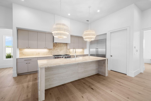 kitchen featuring sink, light hardwood / wood-style floors, decorative light fixtures, gray cabinets, and appliances with stainless steel finishes