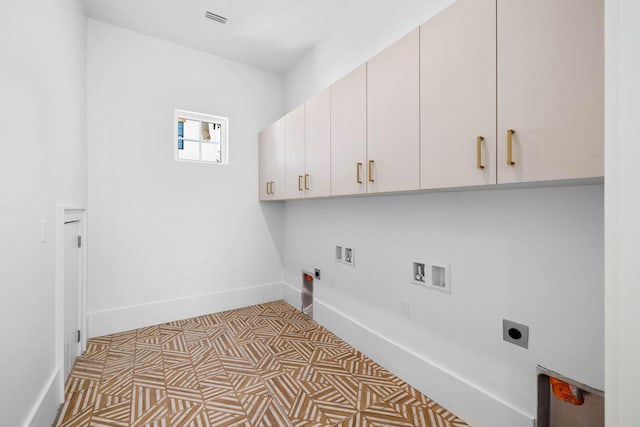 laundry area featuring cabinets, washer hookup, electric dryer hookup, light tile patterned floors, and hookup for a gas dryer