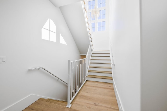 stairs with lofted ceiling and wood-type flooring