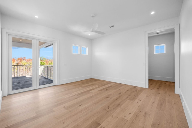 empty room with ceiling fan, a healthy amount of sunlight, and light hardwood / wood-style floors