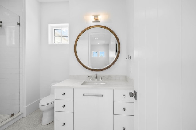 bathroom with vanity, toilet, and a shower with door