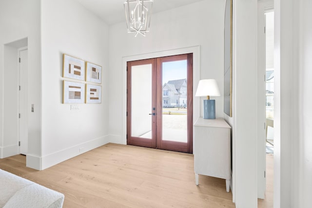 doorway to outside featuring baseboards, french doors, plenty of natural light, and light wood-style floors