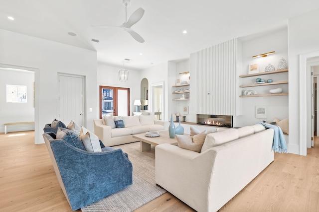 living area featuring recessed lighting, a ceiling fan, visible vents, light wood-type flooring, and a glass covered fireplace