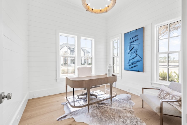 office with light wood finished floors and a chandelier