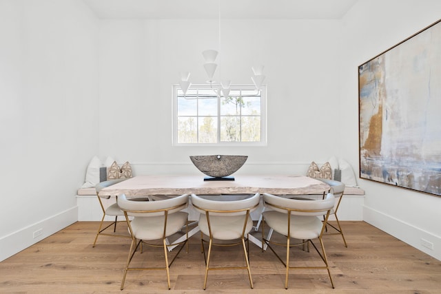 dining space with baseboards, breakfast area, and wood finished floors