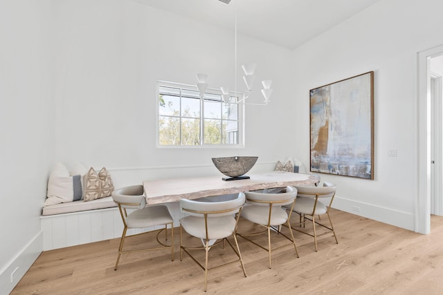 dining room with a notable chandelier, breakfast area, wood finished floors, and baseboards