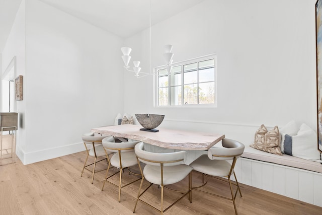 dining room with a chandelier, breakfast area, baseboards, and light wood-style floors