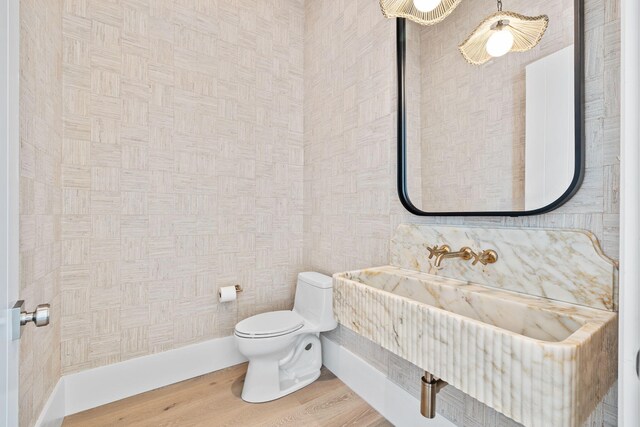 half bath with toilet and wood finished floors