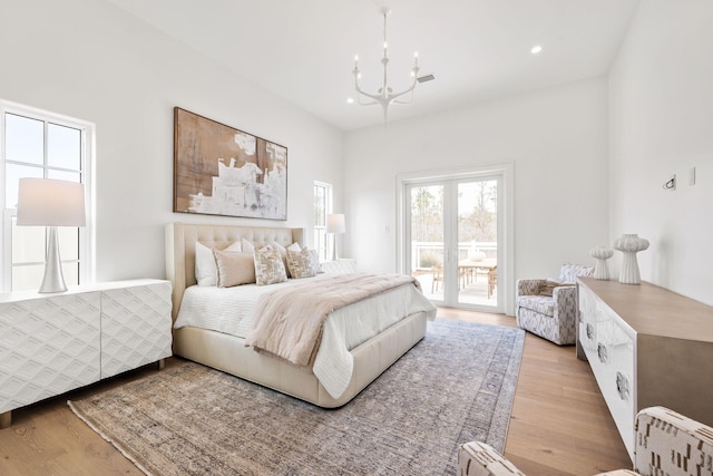 bedroom featuring access to outside, recessed lighting, an inviting chandelier, and wood finished floors