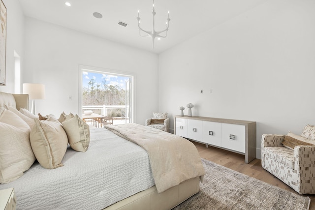 bedroom with light wood finished floors, visible vents, an inviting chandelier, and recessed lighting