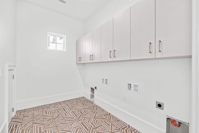 laundry room featuring washer hookup, cabinet space, gas dryer hookup, electric dryer hookup, and baseboards