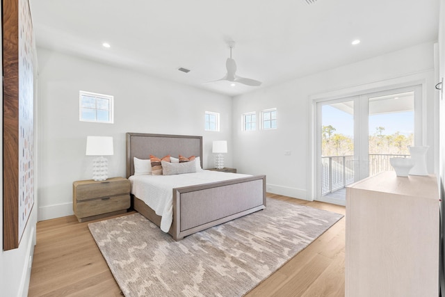 bedroom with baseboards, light wood-style floors, multiple windows, and access to exterior