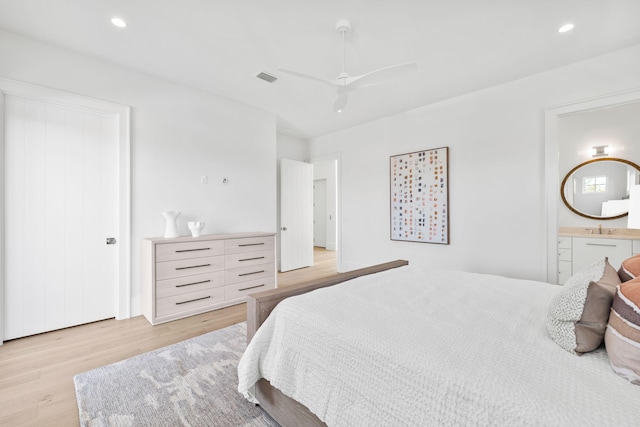 bedroom featuring recessed lighting, visible vents, connected bathroom, a sink, and light wood-type flooring