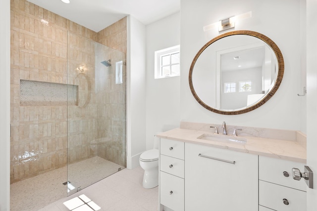 full bathroom with tiled shower, vanity, toilet, and tile patterned floors