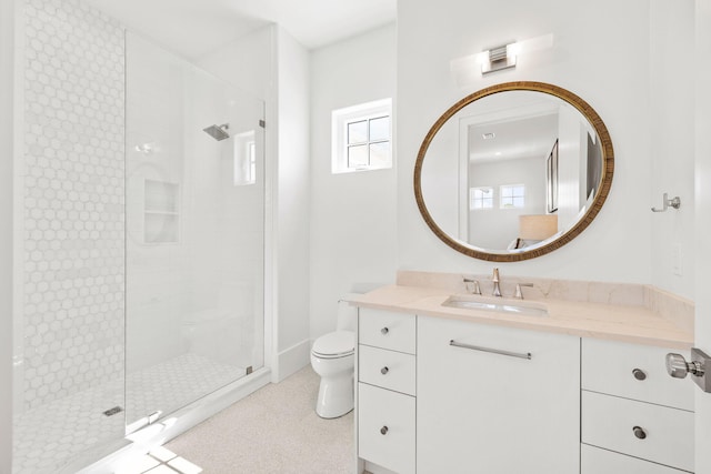 full bath featuring a tile shower, vanity, and toilet