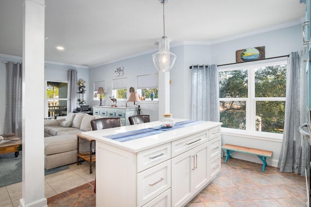 kitchen with crown molding, pendant lighting, light tile patterned floors, a center island, and white cabinetry