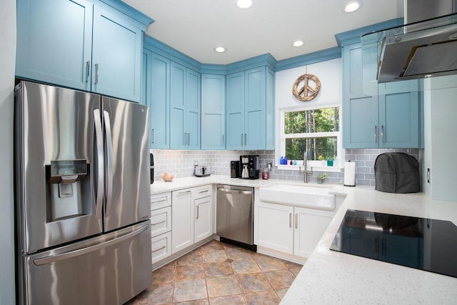 kitchen featuring appliances with stainless steel finishes, tasteful backsplash, sink, blue cabinetry, and white cabinetry