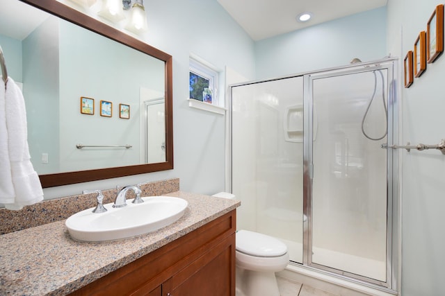 bathroom with tile patterned floors, vanity, toilet, and a shower with shower door