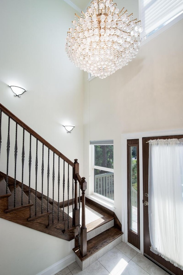 tiled entryway with a wealth of natural light and an inviting chandelier