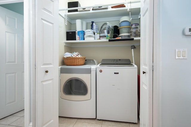 laundry room with light tile patterned floors and washer and clothes dryer