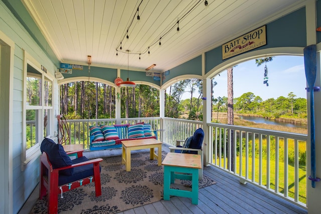 sunroom / solarium featuring a water view