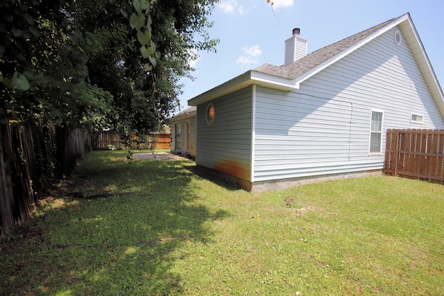 view of side of home with a lawn