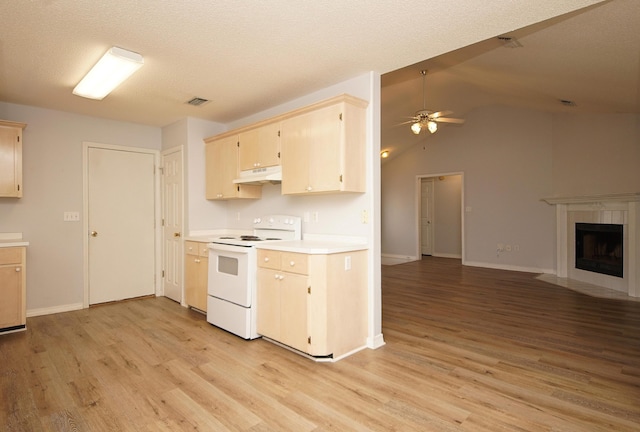 kitchen with a tile fireplace, vaulted ceiling, white range with electric stovetop, and light hardwood / wood-style floors