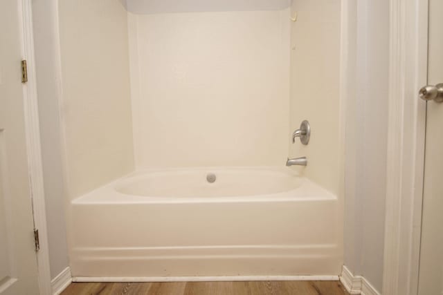 bathroom with a bath and hardwood / wood-style flooring