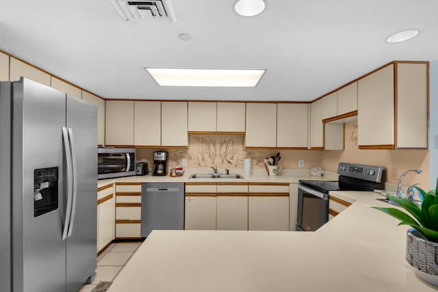 kitchen with sink, cream cabinetry, and appliances with stainless steel finishes