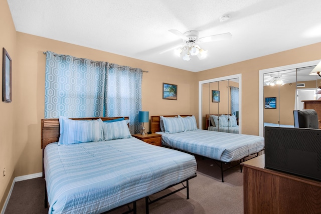 carpeted bedroom featuring ceiling fan and two closets