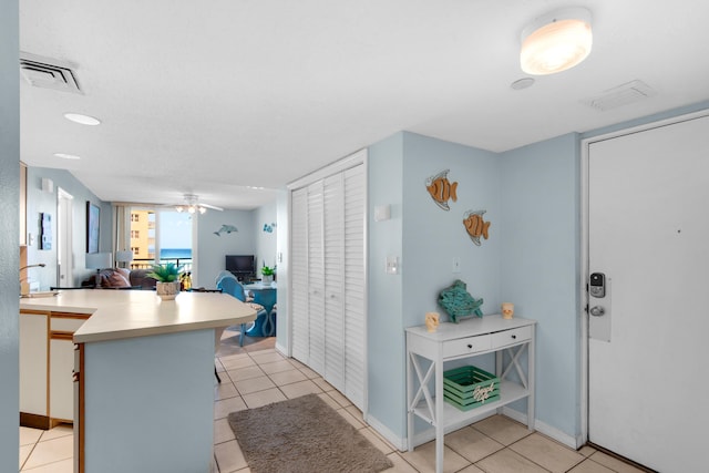 kitchen featuring light tile patterned flooring, ceiling fan, and kitchen peninsula