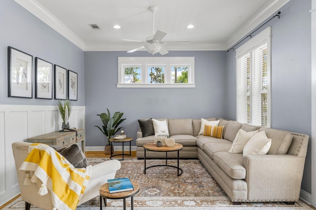 living room featuring hardwood / wood-style floors, ceiling fan, and crown molding