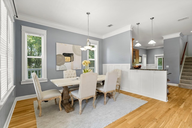 dining area with a wealth of natural light, light hardwood / wood-style flooring, and crown molding