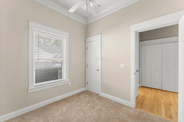 unfurnished bedroom with ceiling fan, a closet, light colored carpet, and ornamental molding