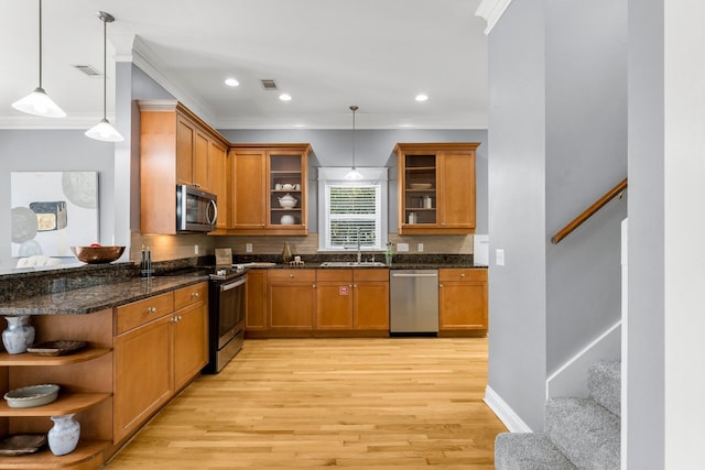 kitchen with crown molding, stainless steel appliances, and decorative light fixtures