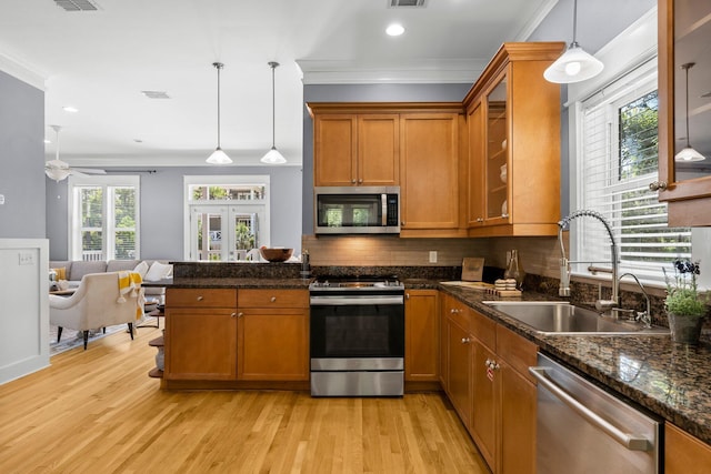 kitchen with decorative backsplash, stainless steel appliances, ceiling fan, sink, and decorative light fixtures