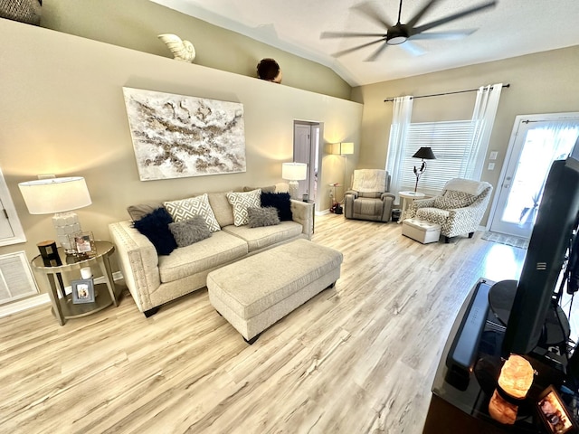 living room with lofted ceiling, ceiling fan, and light hardwood / wood-style floors