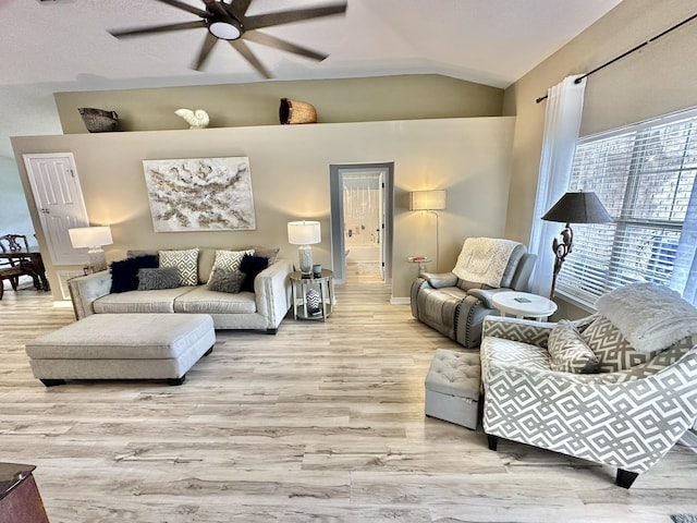 living room featuring lofted ceiling, ceiling fan, and light hardwood / wood-style floors