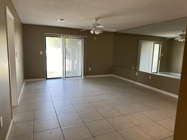 unfurnished room with light tile patterned floors, a textured ceiling, and ceiling fan