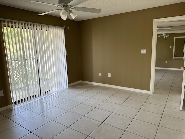 unfurnished room featuring ceiling fan, light tile patterned floors, and a textured ceiling