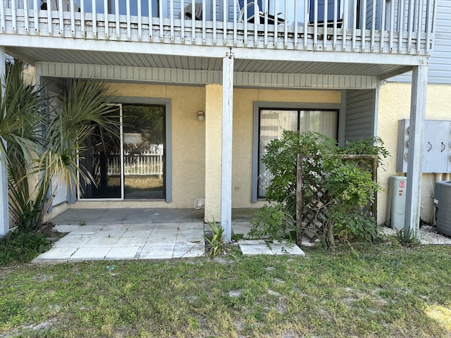 view of exterior entry with a patio and a balcony