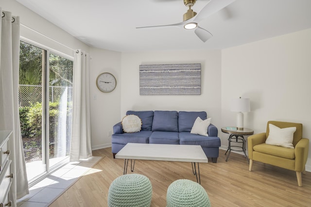 living room featuring light wood finished floors, ceiling fan, and baseboards